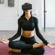 girl wearing virtual reality glasses to watch a yoga class